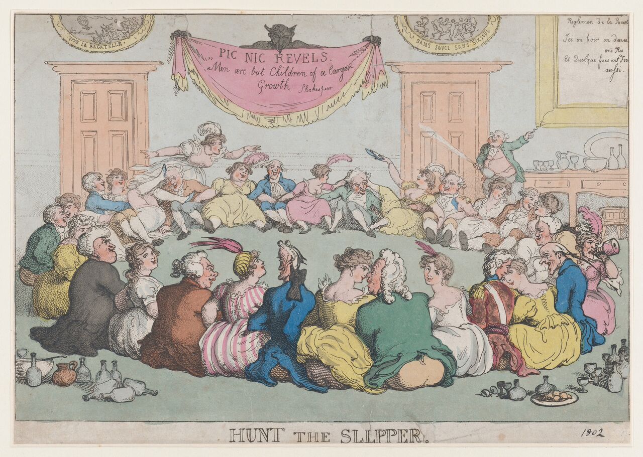 A circle of about 30 slightly raucous men and women in colorful clothing sit on the floor