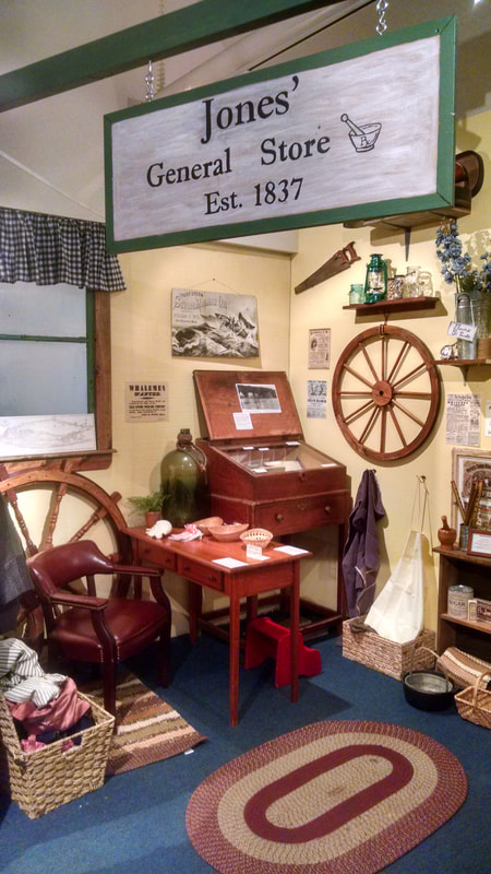 Interior view of Jones General Store exhibit area, with an array of 19th century items for sale and a merchant's desk.